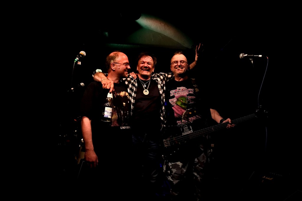 The band Nekropolis '22 taking a bow on stage, arm in arm